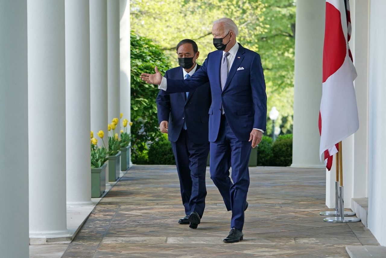 El primer ministro Suga Yoshihide, a la izquierda, junto al presidente estadounidense Joe Biden en la Casa Blanca el 16 de abril de 2021. (© AFP/Jiji)