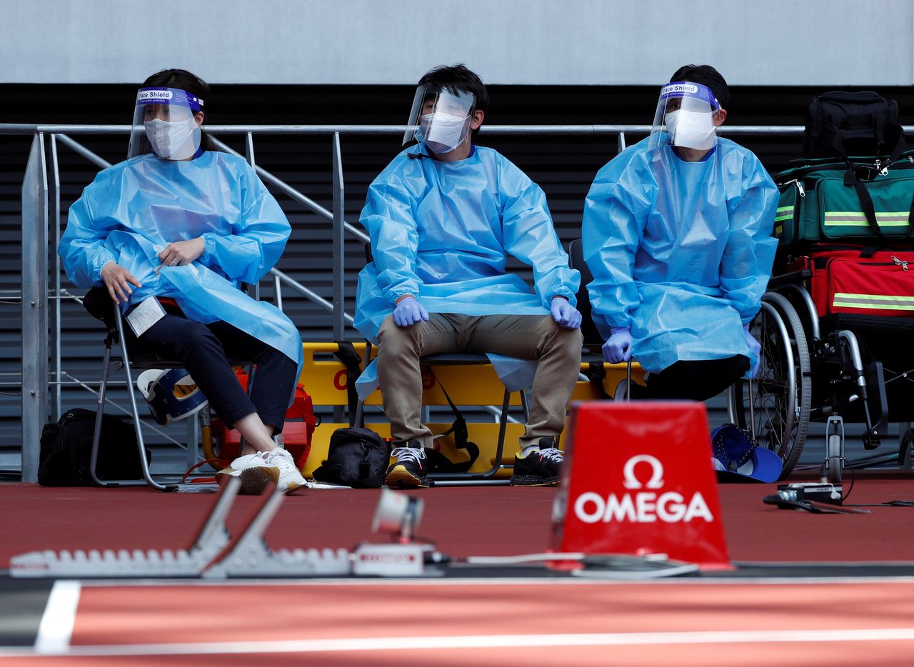 FILE PHOTO: Olympics - Tokyo 2020 Olympic Games Test Event - Athletics - Olympic Stadium, Tokyo, Japan - May 9, 2021. Medical officers wearing protective suits are seen at the morning session of the Athletics test event. REUTERS/Issei Kato/File Photo