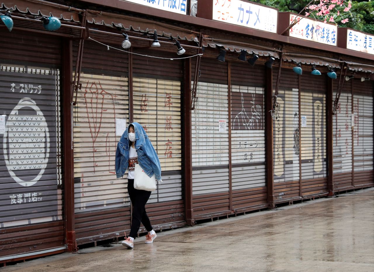 Una mujer con una mascarilla camina frente a las tiendas cerradas en el distrito de Asakusa en Tokio, Japón, el 7 de mayo de 2021. REUTERS/Kim Kyung-Hoon