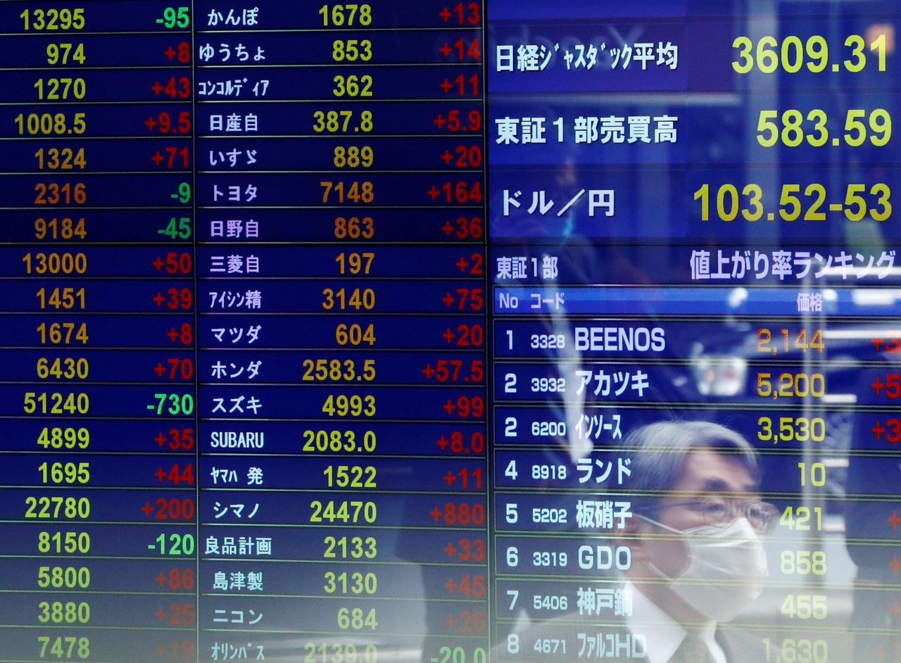 FOTO DE ARCHIVO: Un hombre reflejado en una pantalla con datos de cotización bursátil en Tokio, Japón, el 6 de noviembre de 2020. REUTERS/Issei Kato