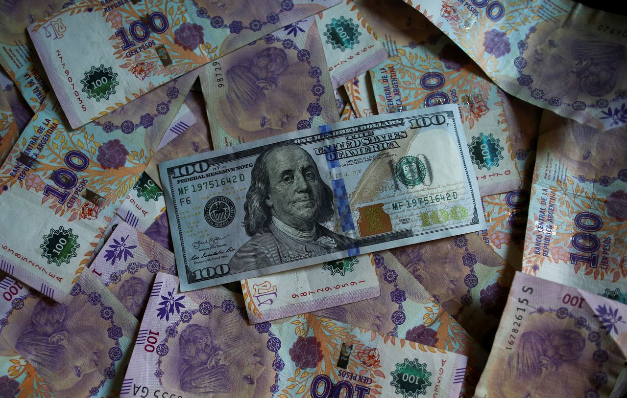 Foto de archivo - Un billete de cien dólares estadounidenses reposa sobre billetes devaluados de cien pesos de Argentina en ilustración fotográfica. Sep 3, 2019. REUTERS/Agustin Marcarian/Illustration
