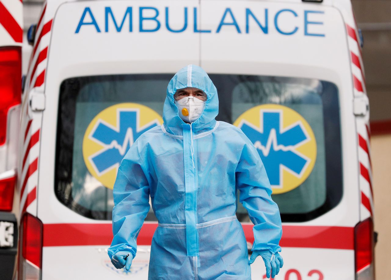 FOTO DE ARCHIVO: Un trabajador sanitario con un equipo de protección individual frente a una ambulancia en el exterior de un hospital para pacientes de COVID-19 en Kiev, Ucrania, el 24 de noviembre de 2020.  REUTERS/Gleb Garanich