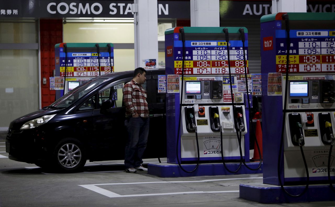 FOTO DE ARCHIVO: Un hombre espera mientras reposta el depósito de su automóvil en una gasolinera de Tokio, Japón, el 16 de diciembre de 2015. REUTERS/Yuya Shino