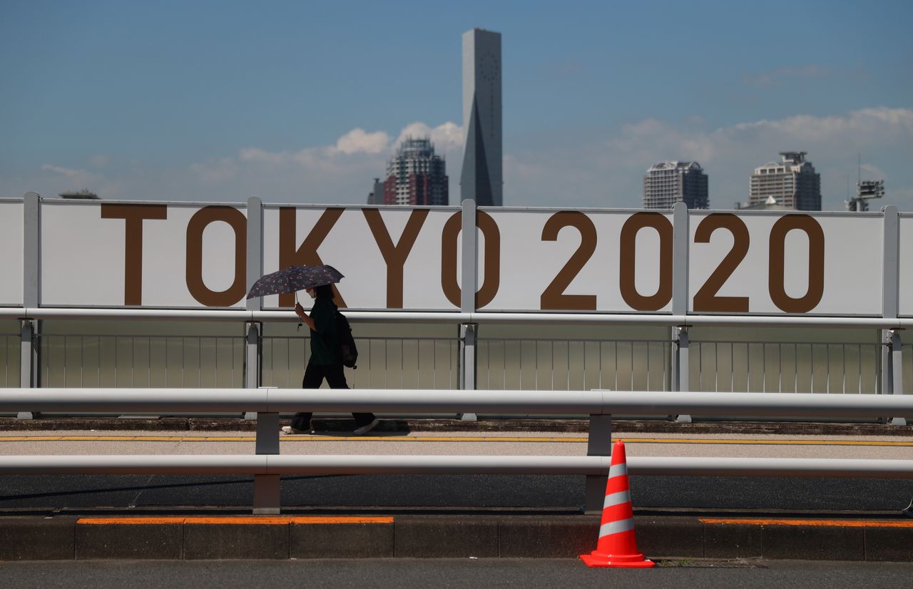Una persona pasa por delante de la señalización de los Juegos Olímpicos, Tokio, Japón, 19 de julio de 2021. REUTERS/Thomas Peter