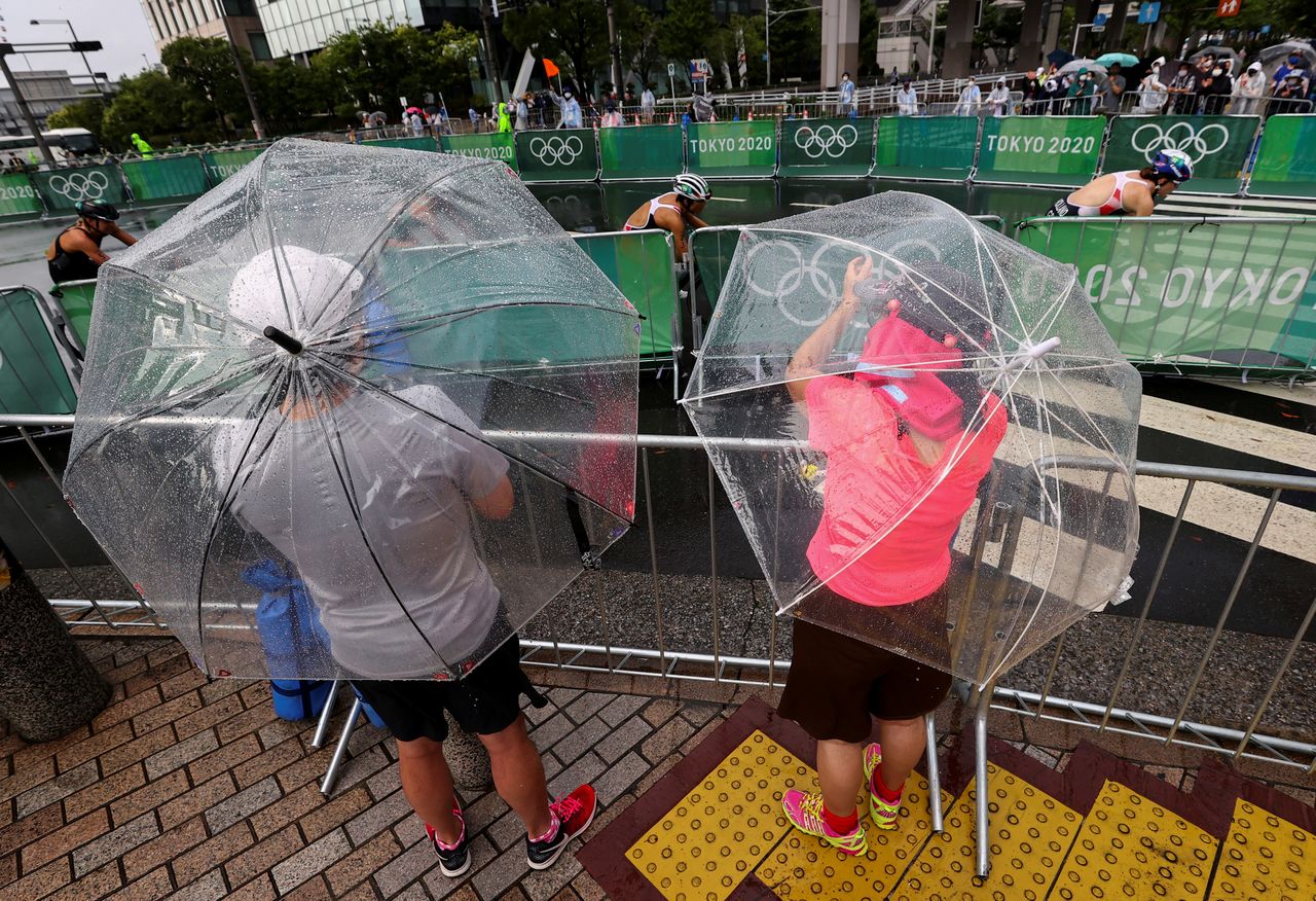 Aficionados y residentes durante la prueba de triatlón femenino bajo la lluvia provocada por la tormenta tropical Nepartak, en el Parque Marino de Odaiba, Tokio, Japón 27 de julio de 2021. REUTERS/Issei Kato