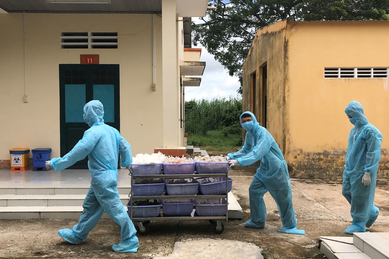 Soldados vietnamitas con trajes de protección empujan un carro con alimentos para las personas repatriadas desde Singapur y puestas en cuarentena durante 14 días en medio de la propagación de la enfermedad del coronavirus (COVID-19) en una base militar en el sur del delta del Mekong, en la provincia de Dong Thap, Vietnam, el 8 de agosto de 2020. REUTERS/Mai Nguyen