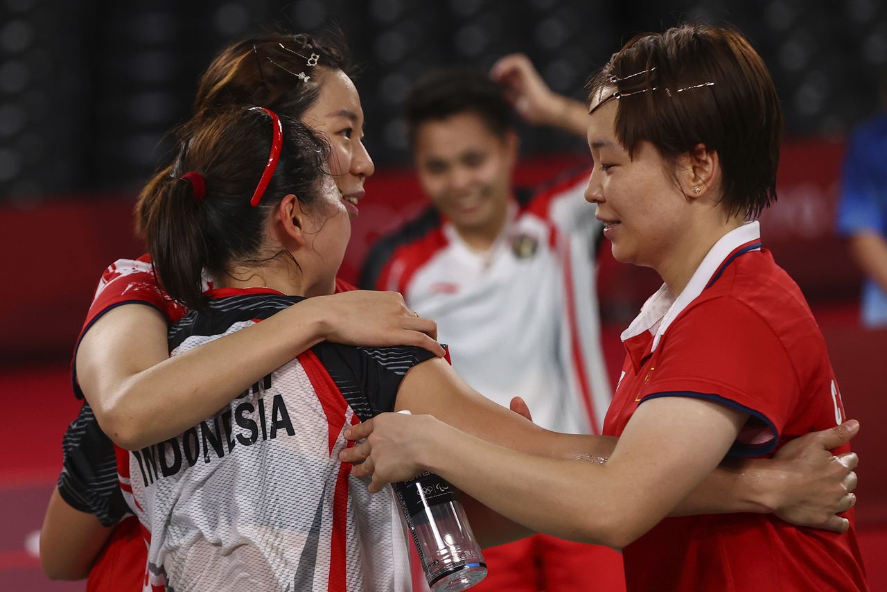 Juegos Olímpicos de Tokio 2020 - Bádminton - Dobles femeninos - Partido por la medalla de oro - MFS - Musashino Forest Sport Plaza, Tokio, Japón - Chen Qingchen de China y Jia Yi Fan de China felicitan a Greysia Polii de Indonesia y Apriyani Rahayu de Indonesia por ganar el partido, 2 de agosto de 2021. REUTERS/Leonhard Foeger