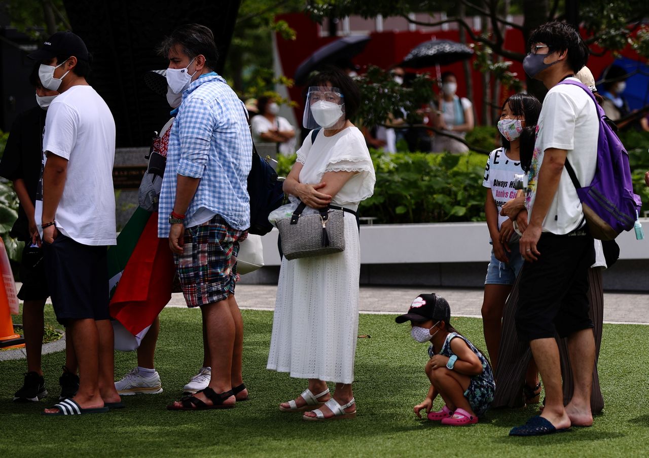 Personas con mascarillas , durante la epidemia de coronavirus (COVID-19), hacen cola para hacerse una foto con un anillo olímpico en el exterior del Estadio Nacional, sede principal de los Juegos Olímpicos de Tokio 2020, en Tokio, Japón, 3 de agosto de 2021. REUTERS/Kim Kyung-Hoon