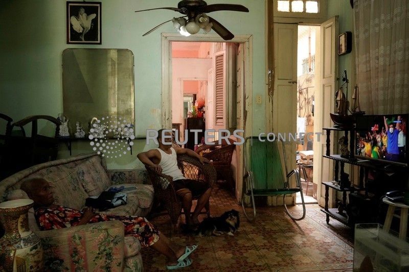 Francisco Cabrera y su madre miran la transmisión del voleibol durante los Juegos Olímpicos de Tokio en medio de la pandemia de coronavirus en La Habana, Cuba, 7 de agosto de 2021. REUTERS/Alexandre Meneghini