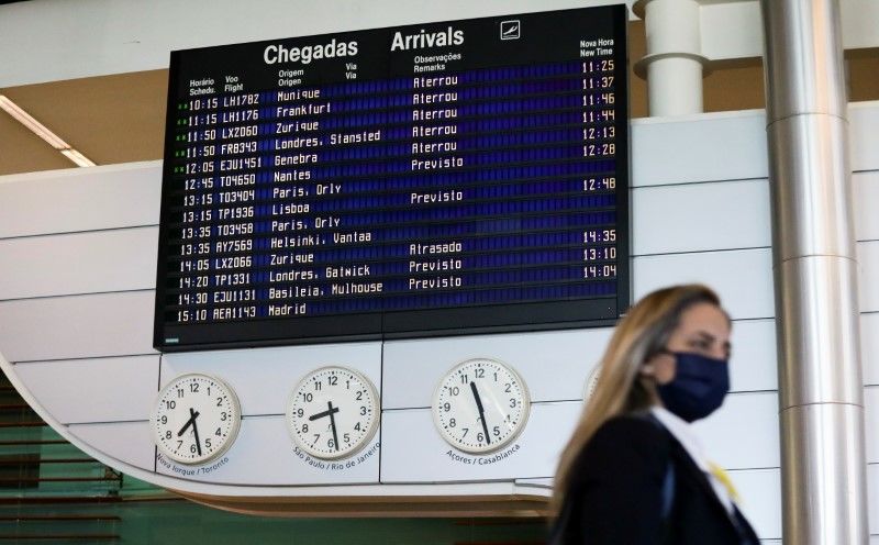 FOTO DE ARCHIVO: Una mujer camina junto al tablón de información de llegadas del aeropuerto de Oporto en Oporto, Portugal, 17 de mayo de 2021. REUTERS/Violeta Santos Moura