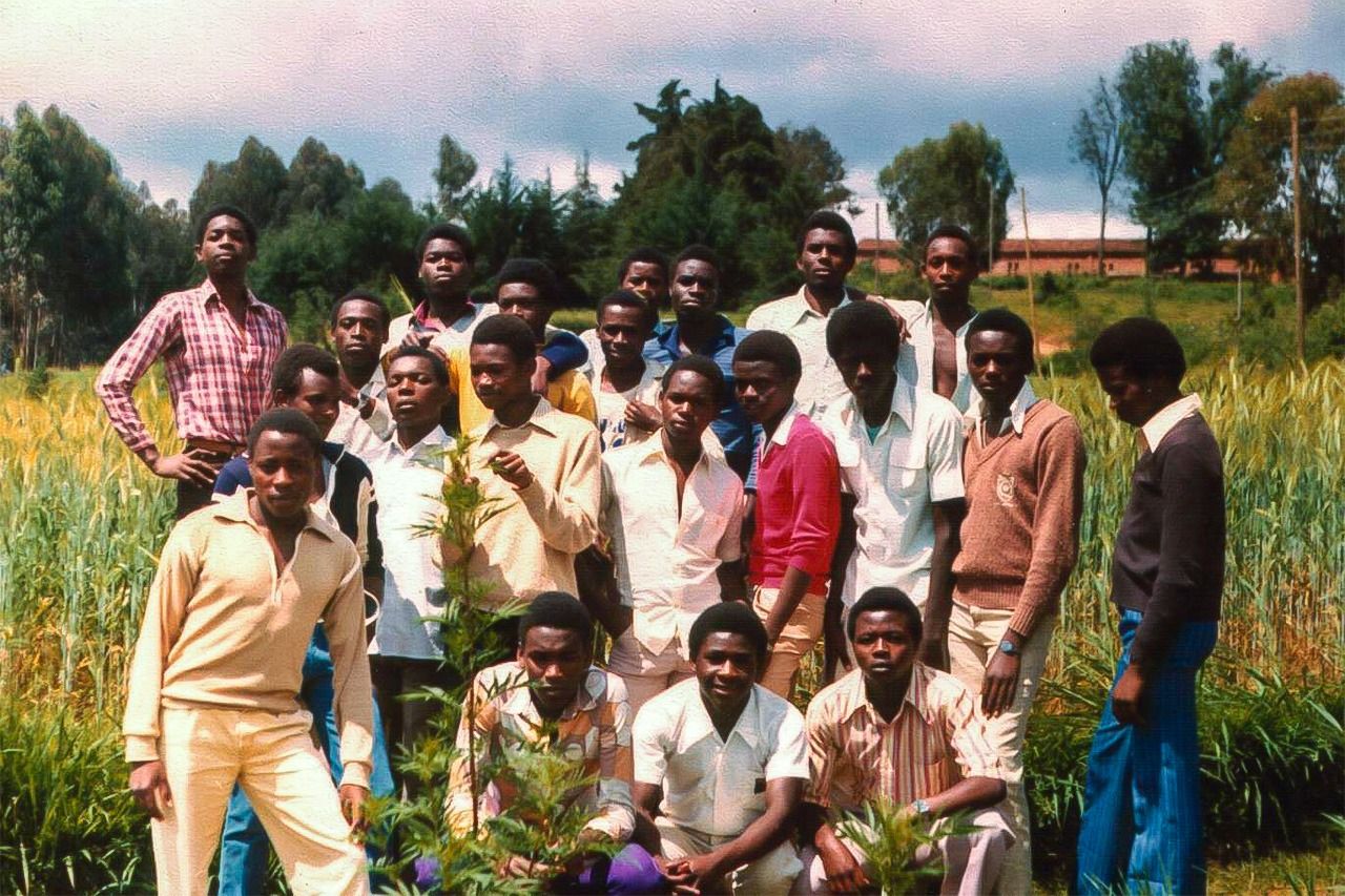 Niyonsaba (tercero por la izquierda al fondo, con el brazo sobre el hombro de un amigo) cerca de su instituto en 1985. (Cortesía de François Niyonsaba)