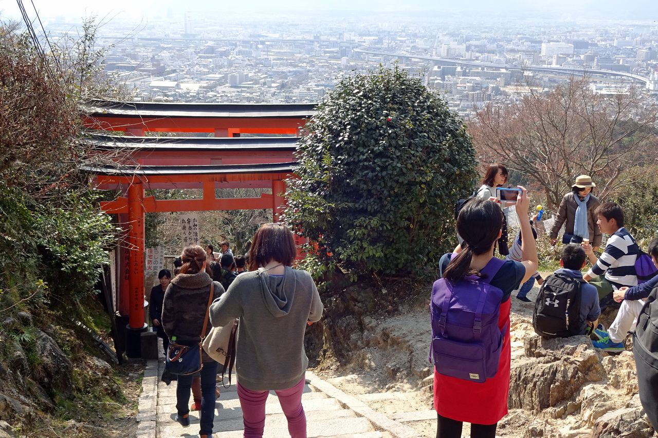 Les visiteurs qui empruntent le chemin d’accès (sandô) du sanctuaire shintô Fushimi Inari taisha de Kyoto ont droit à un point de vue spectaculaire sur l’ancienne capitale impériale du Japon. (Photographie de l’auteur)