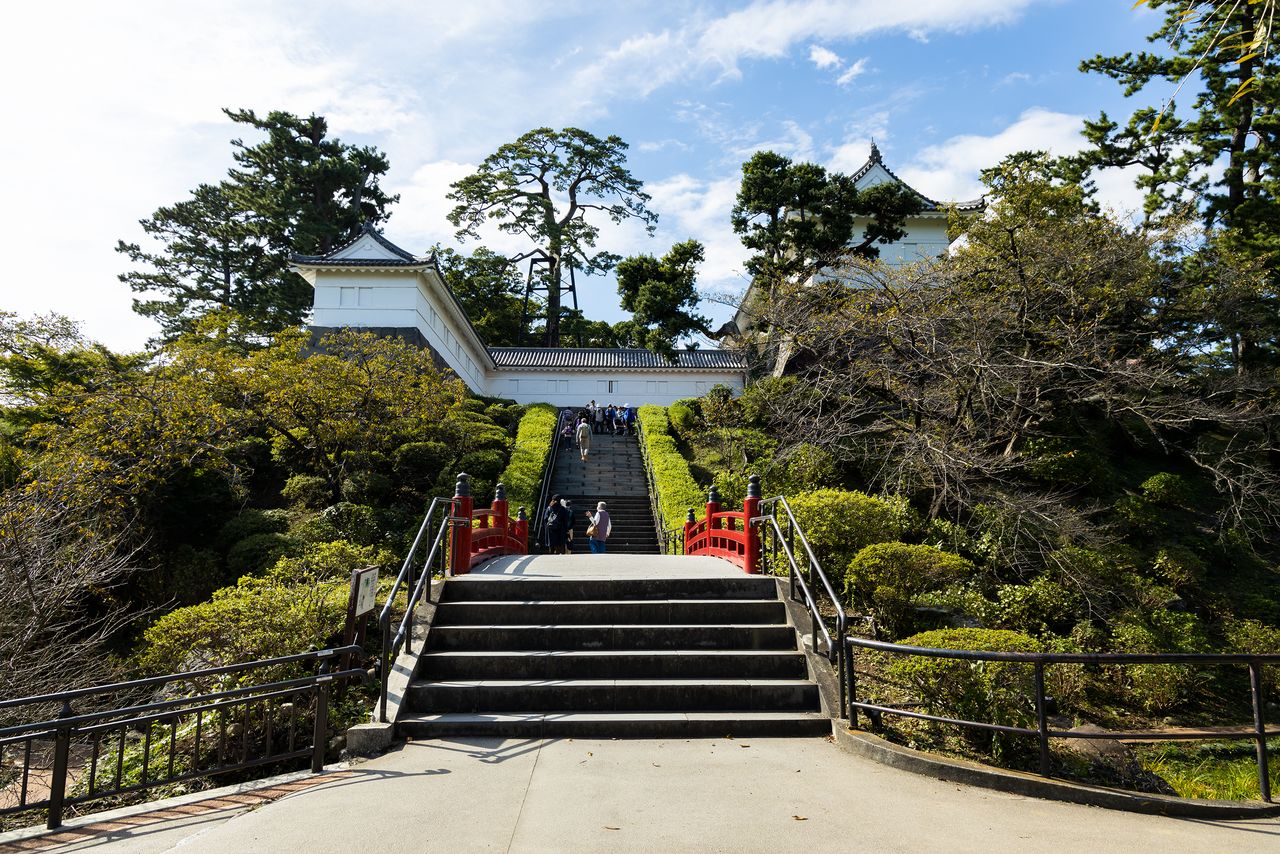 La porte Tokiwagi se trouve au bout des marches en pierre. Des iris japonais (hanashôbu) fleurissent sous le pont vermillon.