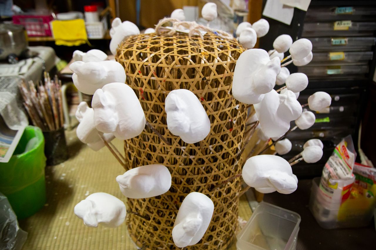 Les formes ainsi obtenues sont enduites de gofun, une poudre blanche naturelle fabriquée à base de coquillages concassés. Ici, les représentations du Rat, l’un des signes du zodiaque. Disposées sur un panier de bambou en forme de balle de riz, elles n’ont plus qu’à sécher.