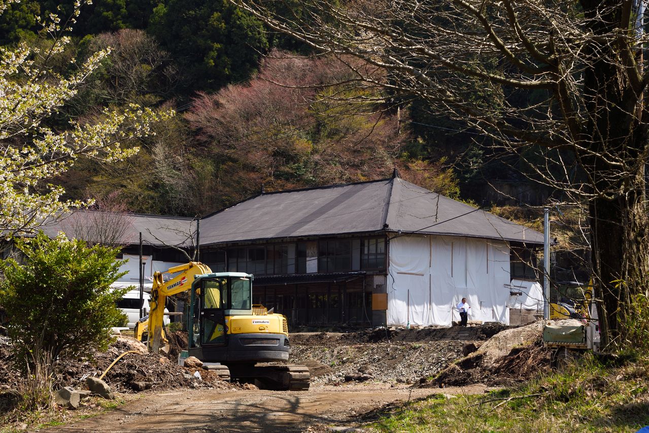 Les travaux de reconstruction du ryokan, dont la structure principale est à l'extrême gauche de la photo, se poursuivent encore aujourd’hui.