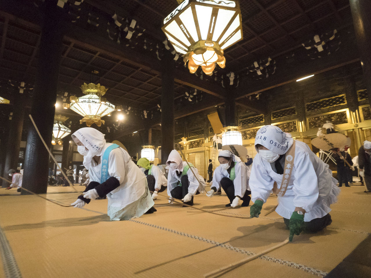 Des femmes frappent les tatamis du temple Nishi-Honganji avec des bâtons en bambou