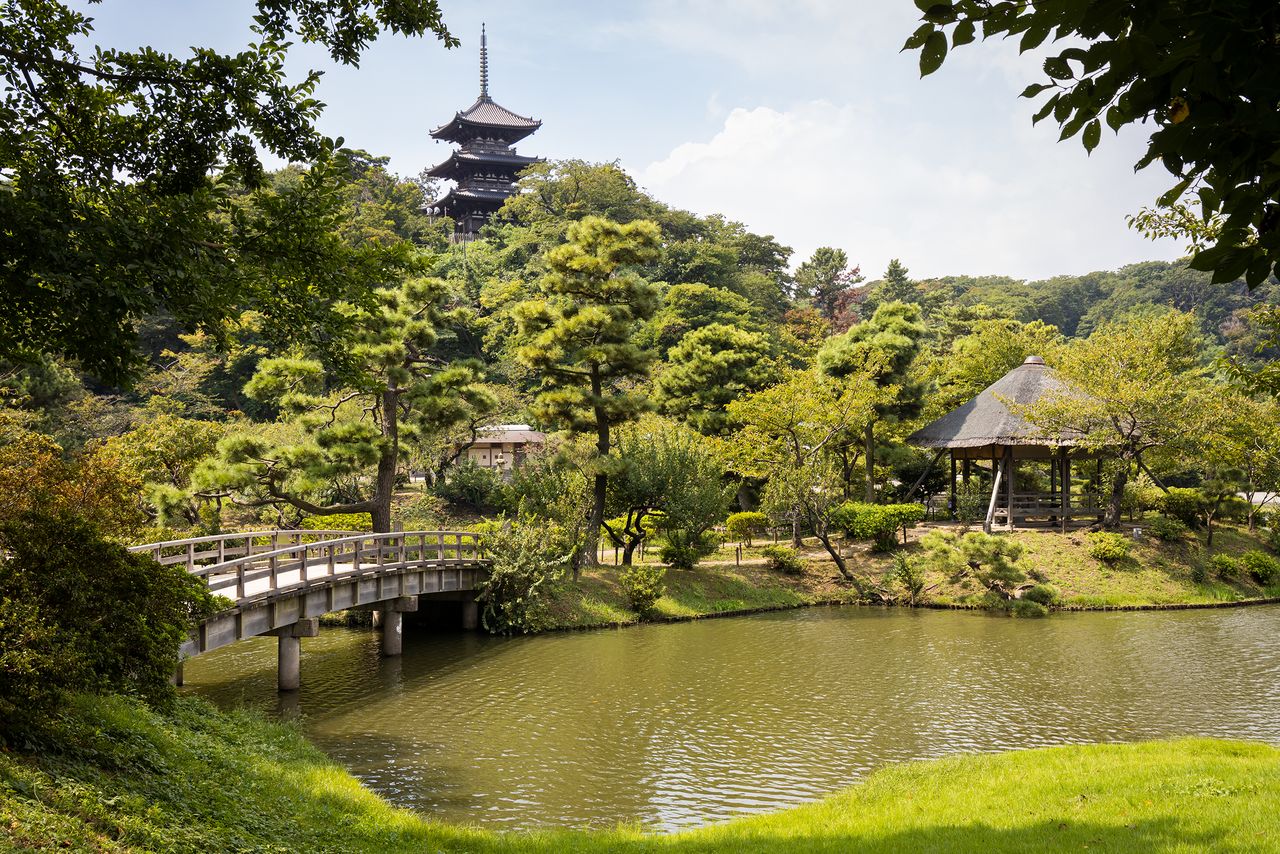 La vue sur l’étang de la pagode à trois étages de l’ancien temple Tômyô-ji, perchée sur une colline. Ce symbole du Sankei-en est un monument culturel important et le bâtiment le plus ancien du jardin.