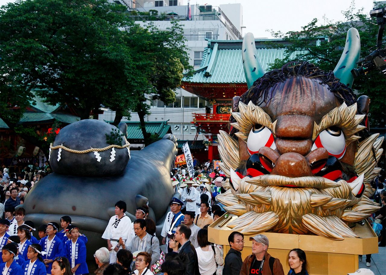 Un yatai à l’apparence d’un yôkai, créature issue du folklore japonais, lors du festival Kanda matsuri, qui se déroule à Tokyo à la mi-mai. Shuten Dôji (à droite) est un puissant démon (oni). Le poisson-chat Namazu (à gauche) aurait le pouvoir de provoquer les tremblements de terre. Il serait maintenu immobile grâce à une pierre sacrée.
