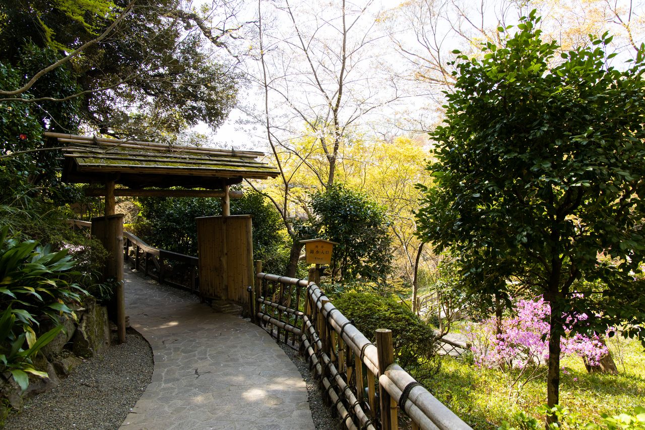 L’élégante porte qui mène au restaurant traditionnel ryôtei. La clôture de bambou qui borde le chemin, fruit du travail de Okayasu Akira et de son équipe, est un véritable enchantement pour les clients étrangers.