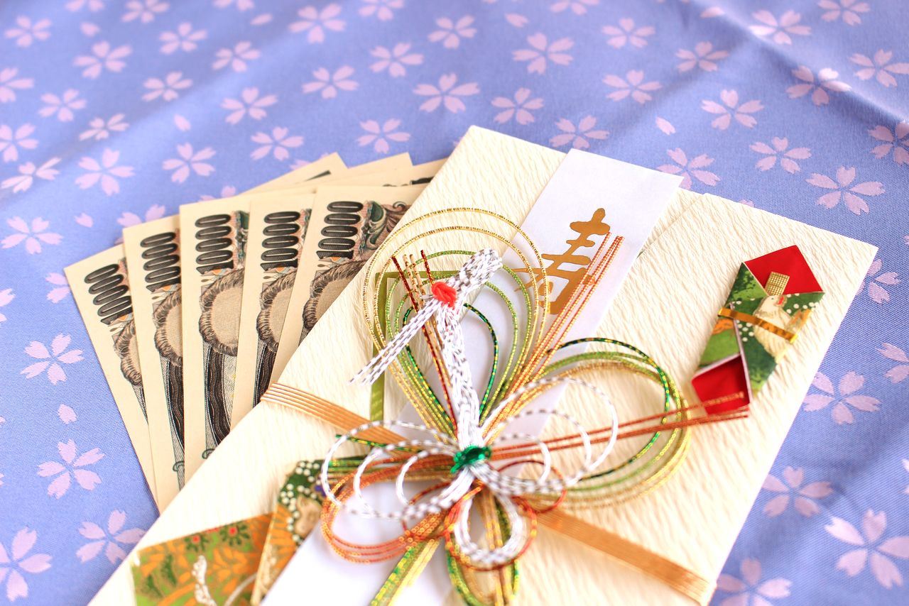 On glisse l’argent offert aux mariés dans une élégante enveloppe. (Pixta)