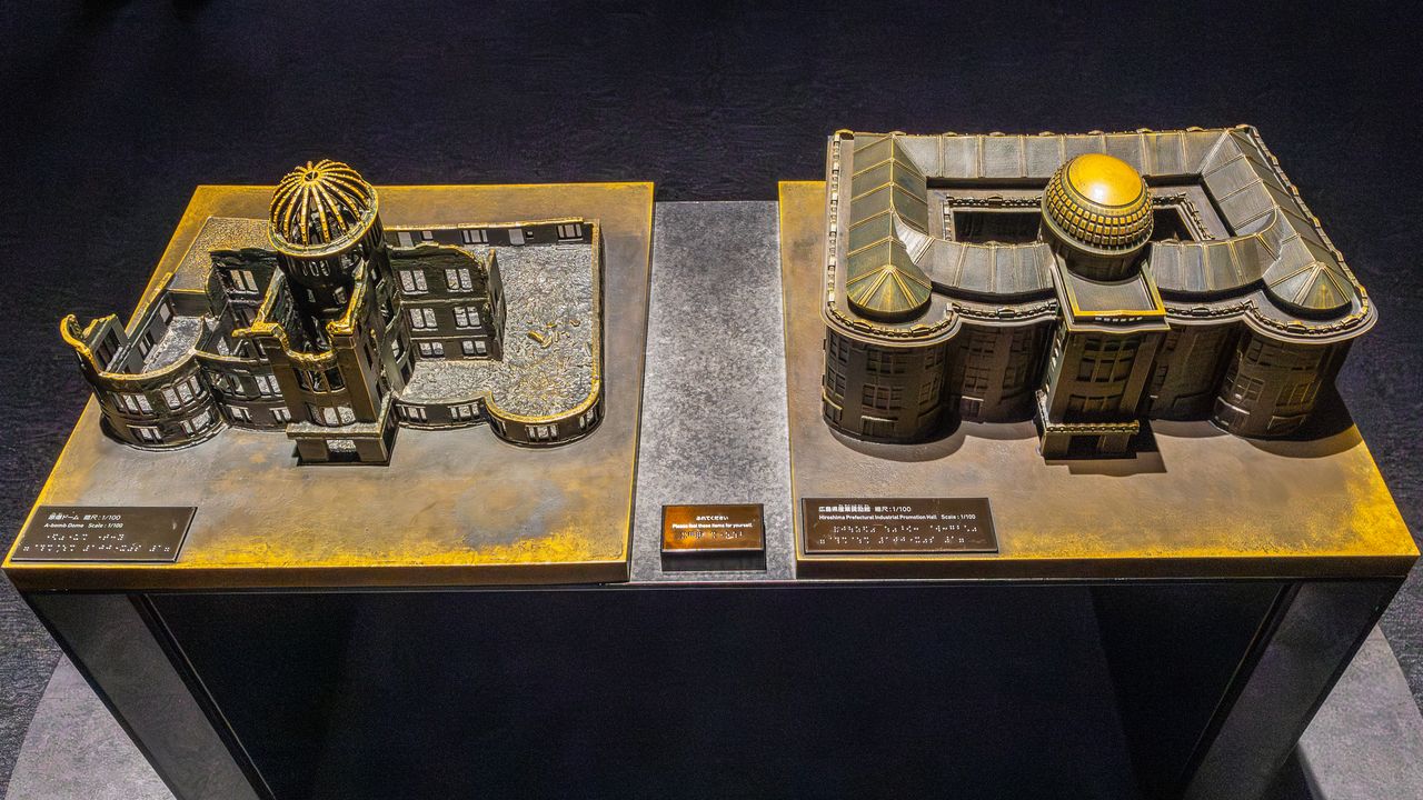 Des éléments tactiles permettent aux mal-voyants de découvrir le Hall de la promotion industrielle de Hiroshima tel qu’il était à l’origine (à droite) ainsi que le Dôme de la bombe atomique d’aujourd’hui.