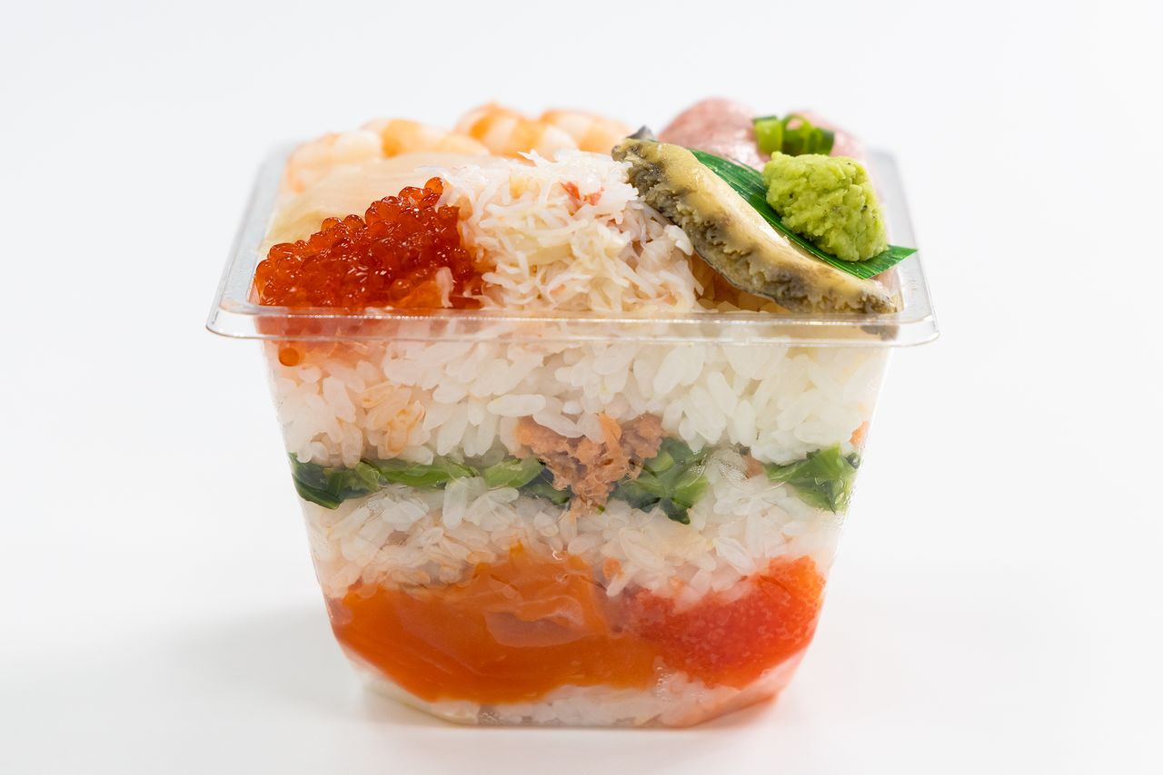 La beauté du saumon et des feuilles de moutarde vertes entrelacées. La couche inférieure est constituée de lamelles de racines de gingembre marinées. (Nippon.com)