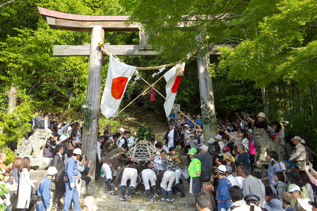 La foule enthousiaste à l’arrivée du mikoshi et des participants sains et saufs. (© Haga Library)