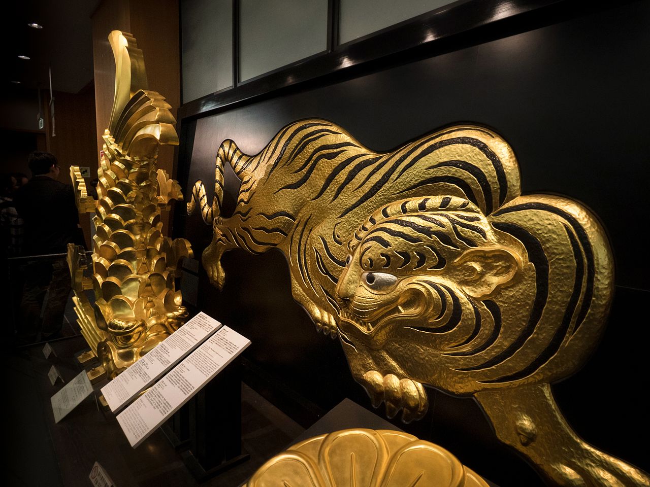 Une réplique des ornements du toit, shachihoko et un tigre dorés, exposés au premier étage.