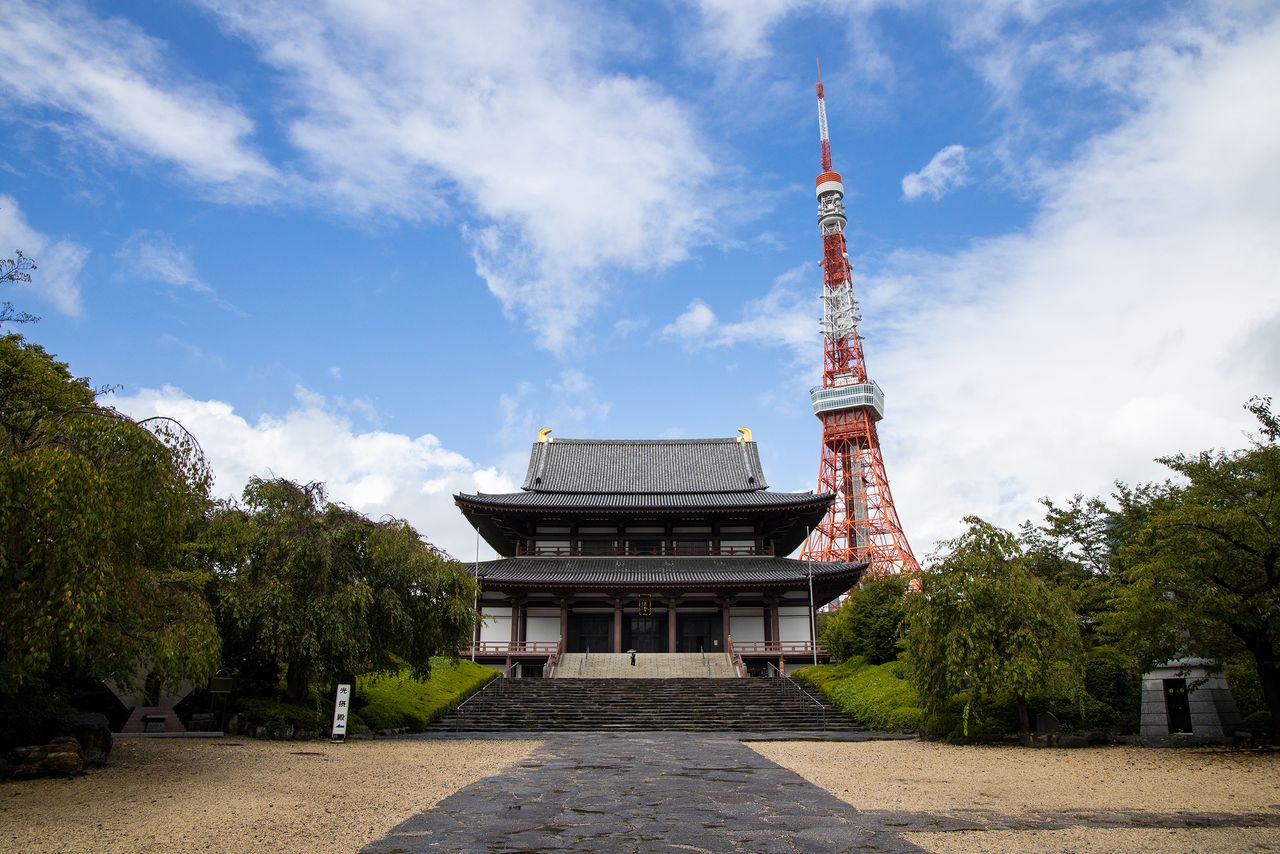 La grande salle Daiden du temple Zôjô-ji, avec la tour de Tokyo qui s’élève majestueuse en arrière-plan.