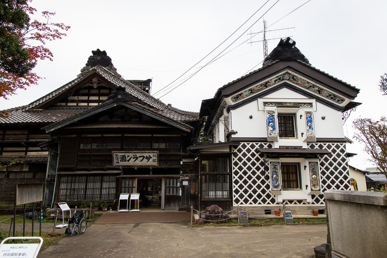 Le bâtiment principal de Kina Safuran-shu Honpo se trouve sur la gauche, et sur la droite se trouve l’entrepôt avec ses décorations particulières en stuc, du type koto-e
