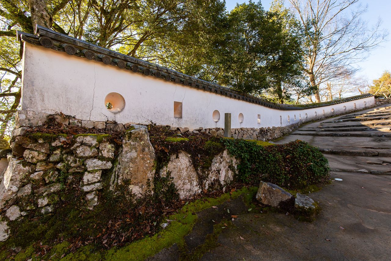 Le mur de pisé de l’est de la « troisième tour à un niveau » (san no hira yagura) du château de Bitchû Matsuyama est percé de meurtrières. Il a été classé bien culturel important du Japon. La partie située au premier plan date de l’époque d’Edo (1603-1868). Celle qui borde les marches de pierre a été rajoutée au moment de la restauration des lieux. 