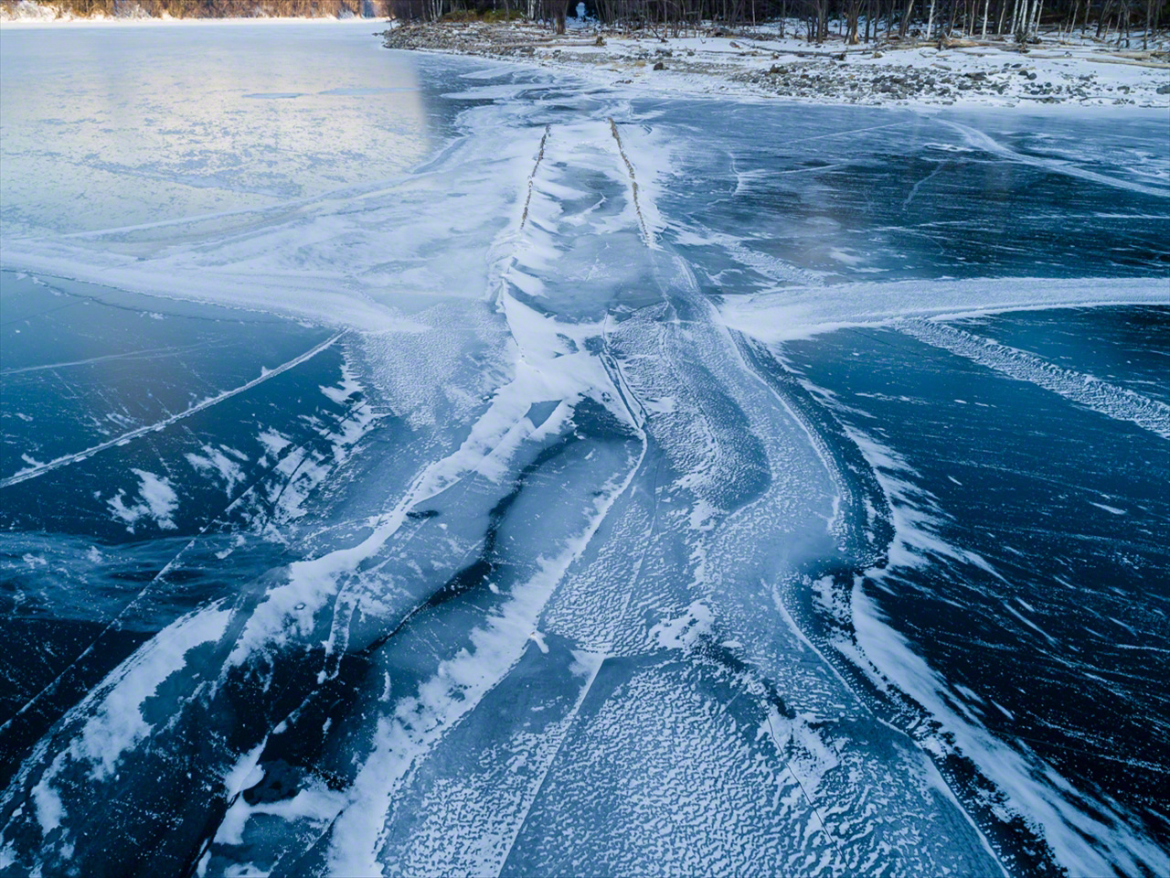 Décembre. Une fine couche de glace se forme sur le lac. Le pont refait progressivement surface à mesure que le niveau d’eau baisse.