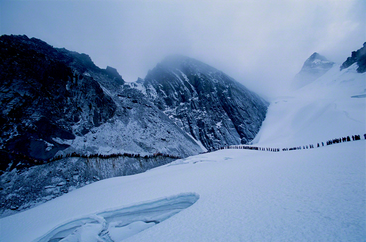 Un groupe d’hommes appelés <em>ukuk</em> (« ours ») démontent la croix qu’ils ont dressée, puis redescendent dans leur vallée, après un rituel lors du pèlerinage de Qoyllur Rit’i, institué depuis que s’est répandue la légende de l’apparition d’une réincarnation du Christ dans un sanctuaire inca. Photo prise en 2004 sur un glacier situé à 5 000 mètres d’altitude dans la cordillère des Andes, au Pérou. (Extrait de « Hauts plateaux extrêmes : vivre au Tibet, dans les Andes, en Éthiopie »)