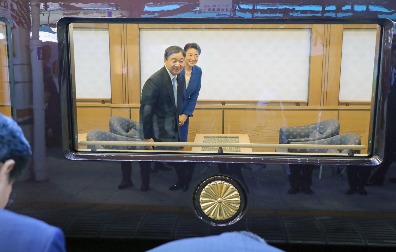 L’empereur Naruhito et l’impératrice Masako en train de saluer, au moment où le train impérial a quitté la gare de Tokyo pour la préfecture d’Ibaraki le 28 septembre 2019, à l’occasion de la Fête nationale du sport. A ce moment-là, les rideaux du wagon impérial étaient ouverts. (Jiji Press, pool photo)