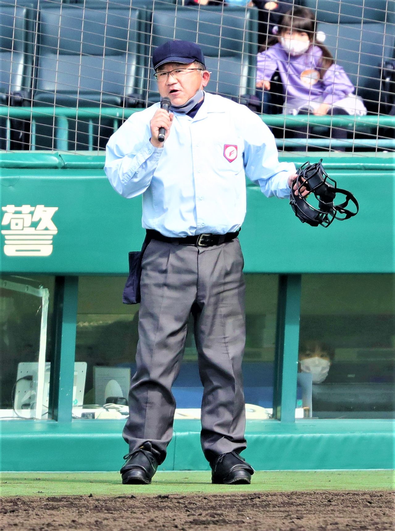 Le micro à la main, l'arbitre de baseball reconnaît son erreur pendant le match de baseball et présente ses excuses, le 20 mars 2022, au stade Kôshien (Jiji).