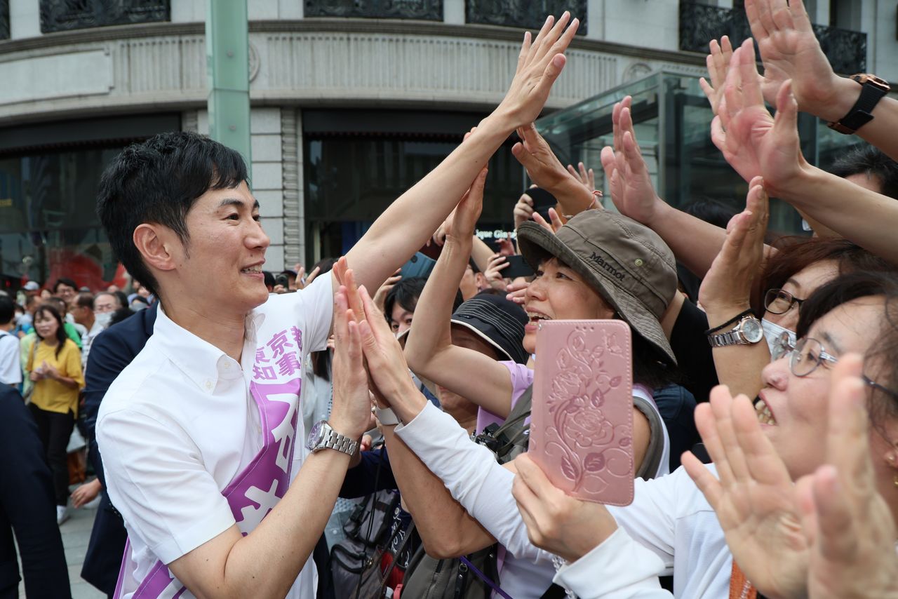 Ishimaru Shinji, anciennement maire d'Akitakata, dans la préfecture de Hiroshima, tape dans les mains de ses sympathisants dans le quartier de Ginza, à Tokyo, le 30 juin 2024. (Jiji)