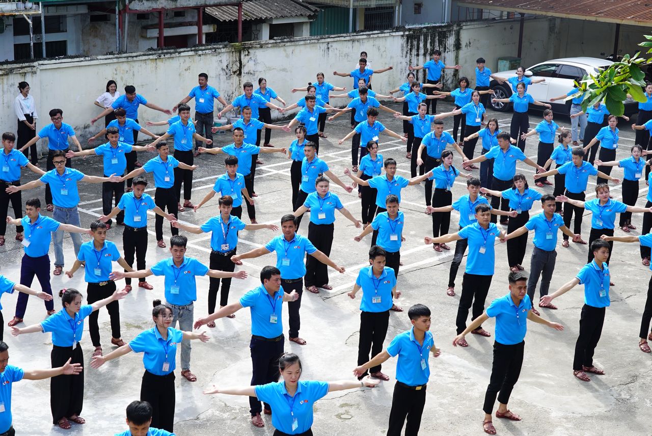 À Hanoï, le 17 juin 2024, de futurs stagiaires exécutent des exercices matinaux de gymnastique suédoise programmés par la radio, dans un centre de formation géré par une organisation d’envoi de stagiaires.