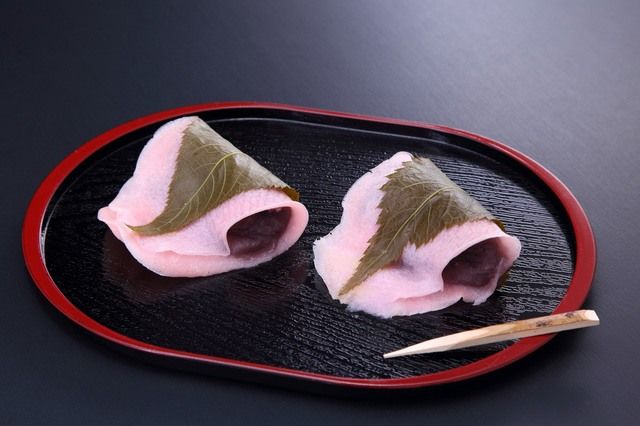 The dessert called sakura mochi.  It is topped with koshian, a red bean paste pressed through a fine sieve, and covered with a rice paste.  It is often appreciated on the occasion of the girls' day on March 3.
