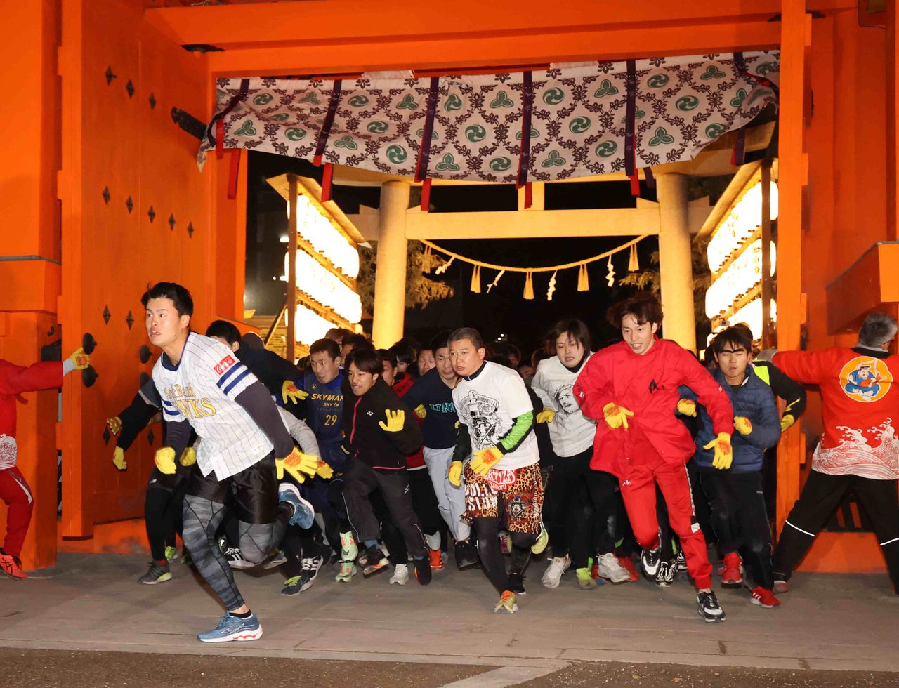 Les coureurs s'élancent pleins d’espoir pour devenir les prochains « hommes chanceux » pour l'année qui débute, au sanctuaire de Nishinomiya. (© Jiji)