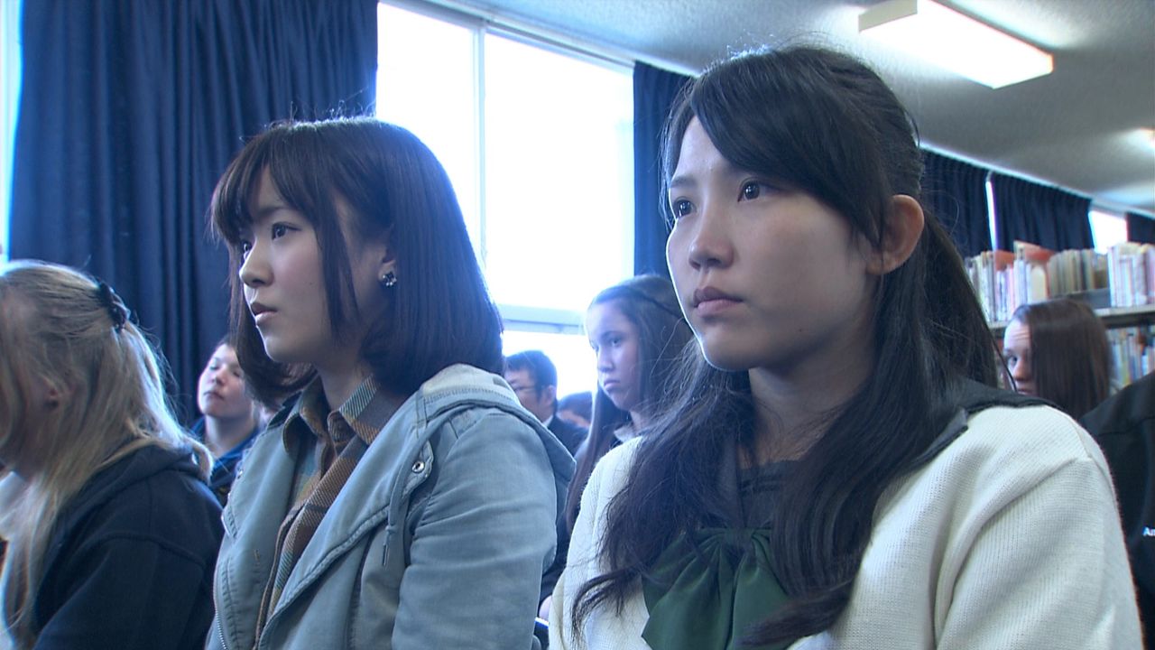 Des élèves et des anciennes élèves du Lycée de filles de San'yô écoutent l'intervention prononcée par Murakami lors de la célébration du soixante-dixième anniversaire au Lycée de Cowra. (© Setonaikai Broadcasting Corporation)