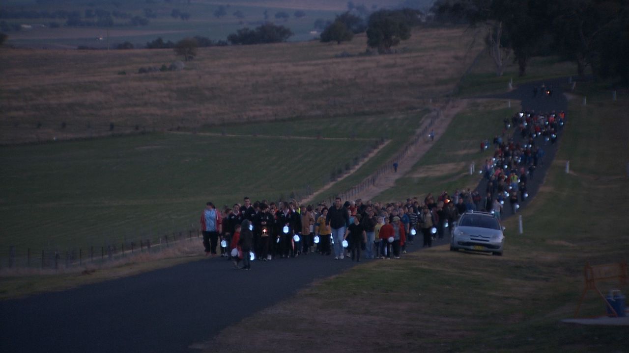 Quatre gardiens australiens ont été tués lors de l'évasion. En 2014, les habitants de Cowra ont participé à une « marche aux flambeaux » à la mémoire des morts et prié pour la paix. (© Setonaikai Broadcasting Corporation)