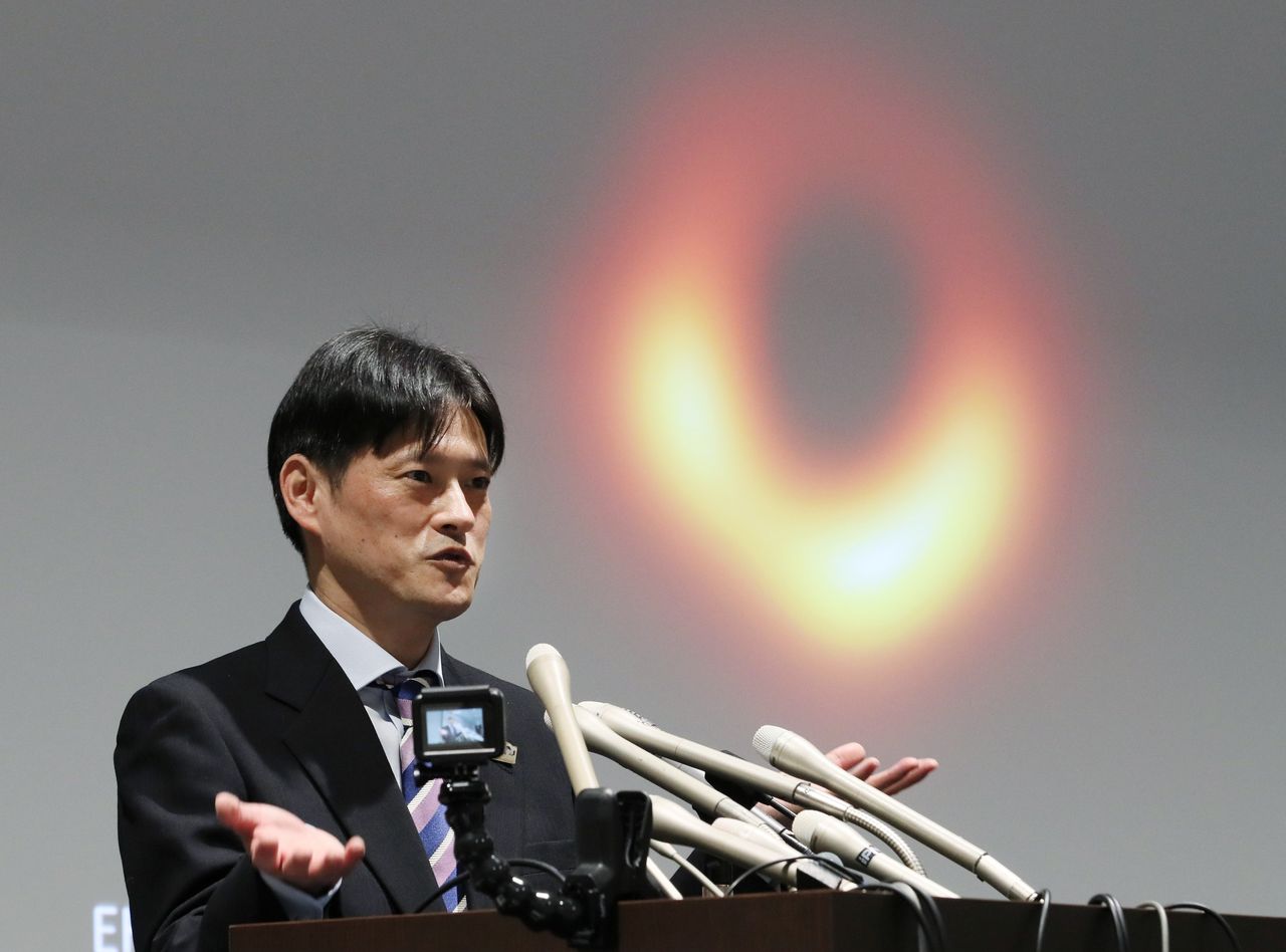 Le professeur Honma Mareki de l'Observatoire astronomique national du Japon présentant les résultats d'un projet sur les trous noirs lors d'une conférence de presse, le 10 avril dans l'arrondissement de Chiyoda à Tokyo (Jiji).