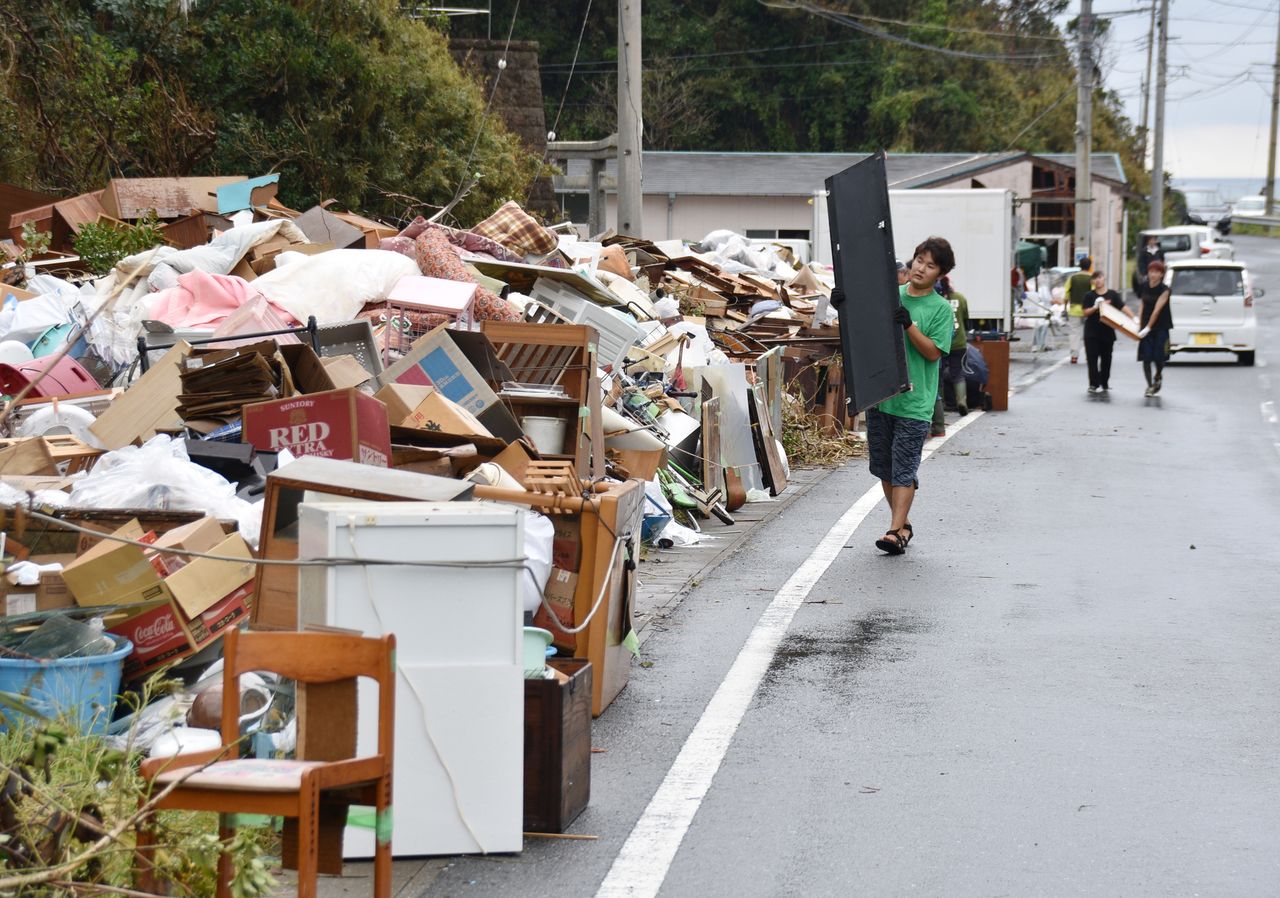 Des habitants de Chiba rassemblant des déchets après le passage dévastateur du typhon Faxai, le 16 septembre à Iwaifukuro dans la ville de Kyonan, préfecture de Chiba. (Jiji Press)