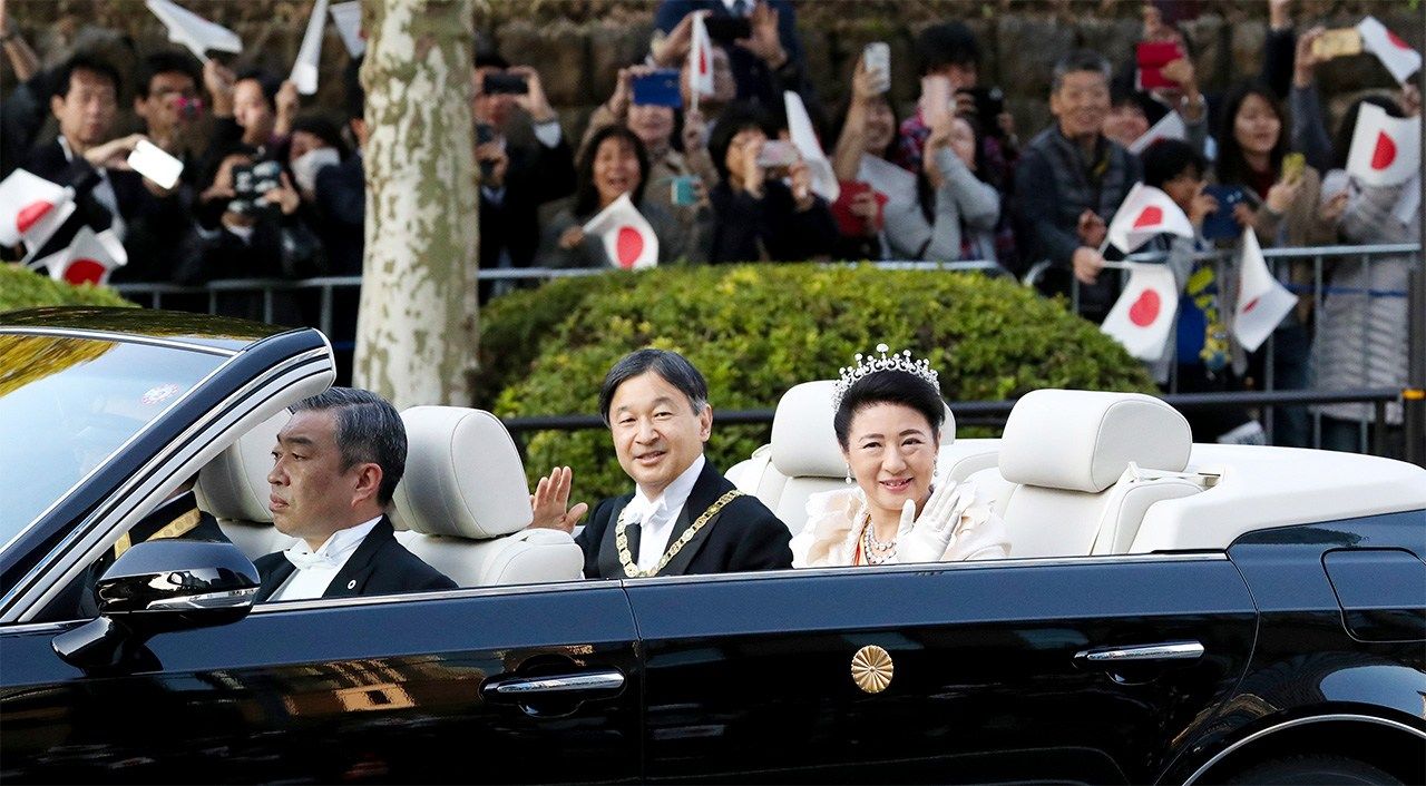 L’empereur Naruhito et l’impératrice Masako saluant la foule le long de la rue Aoyama dans l'arrondissement Minato à Tokyo, le 10 novembre 2019 (Jiji press).