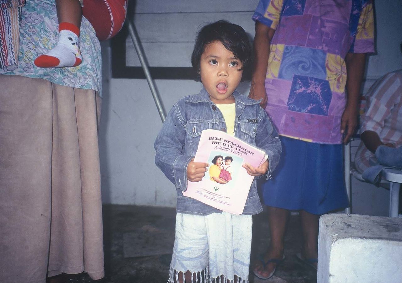 Dans le centre de l’Indonésie, une enfant tenant son manuel de santé maternelle et infantile.