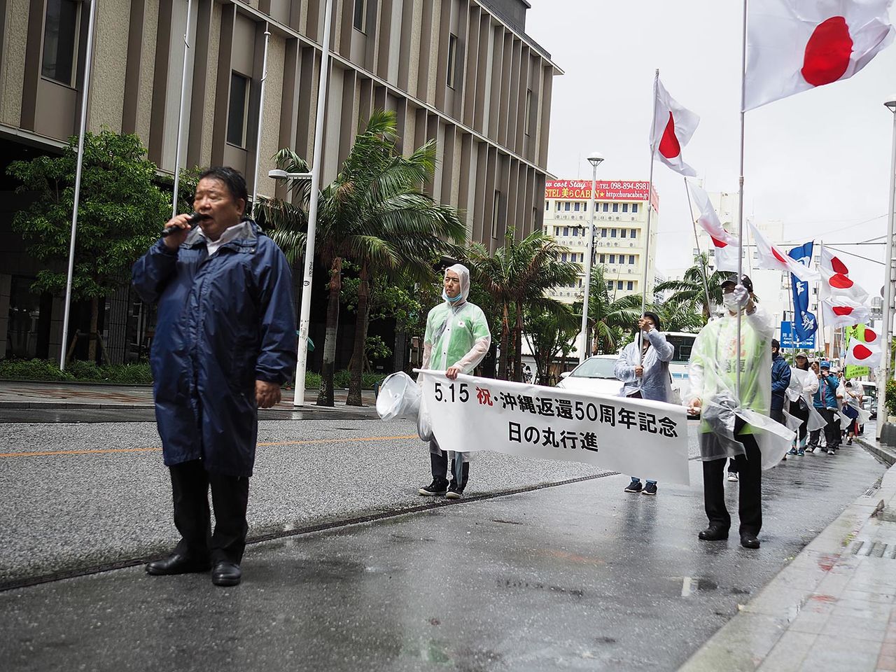 Des organisations célèbrent le 50e anniversaire du retour d'Okinawa au Japon en défilant le long de Kokusai-dôri, drapeau japonais en tête.