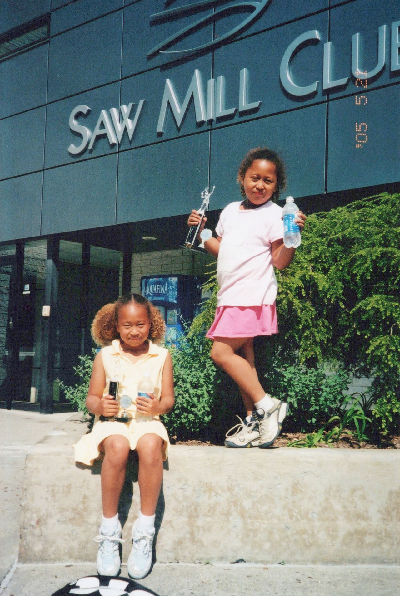 Les deux sœurs Mari (à gauche) et Naomi exhibent fièrement leurs trophées de première place d’un tournoi régional junior de tennis.