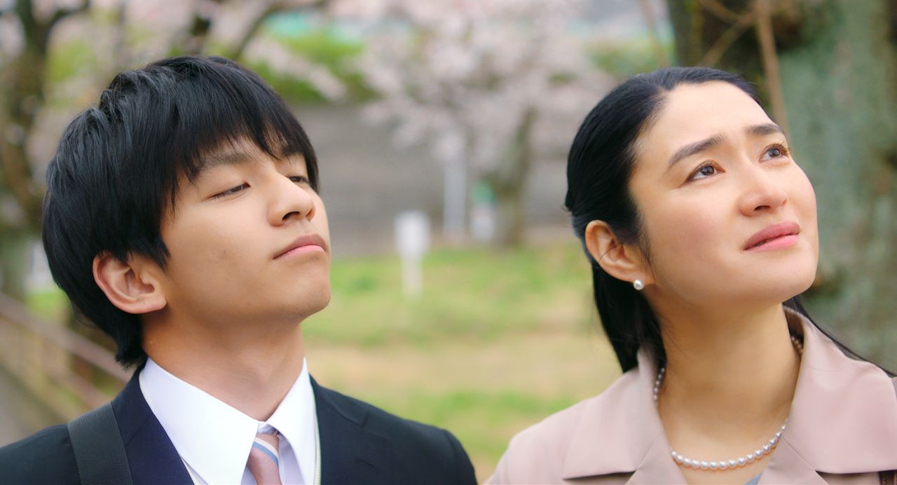 Une scène du film Sakura-iro no Kaze ga Saku (« Un vent de cerisiers en fleurs »). La mère, Reiko, est interprétée par Koyuki, et Satoshi à 18 ans, est joué par Tanaka Taketo ©THRONE / KARAVAN Pictures