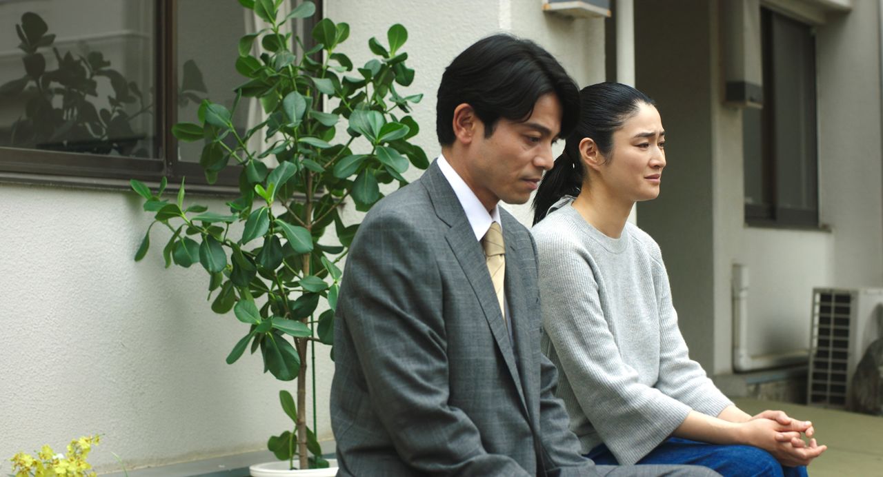 Reiko (Koyuki) choquée d'apprendre que Satoshi est en train de devenir aveugle. À ses côtés, son mari Masami (Yoshizawa Hisashi) la soutient. ©THRONE / KARAVAN Pictures
