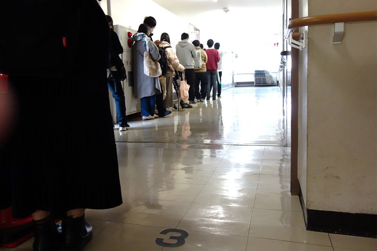 Des étudiants font la queue pendant un événement à la banque alimentaire Food Bank Kanagawa. (© Nippon.com)